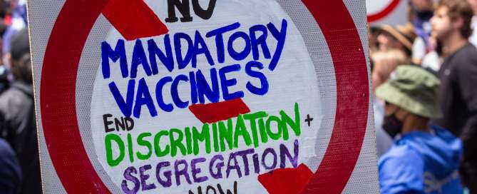 Protest sign with text: no mandatory vaccines, end discrimination plus segregation now